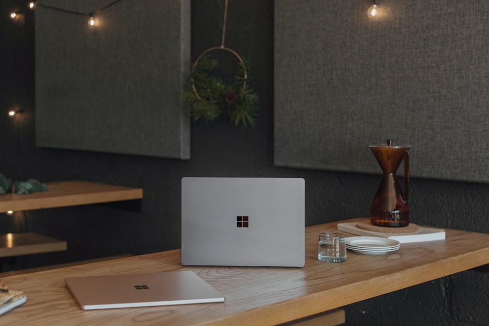 Surface laptops on a table at work with Christmas lights in the background